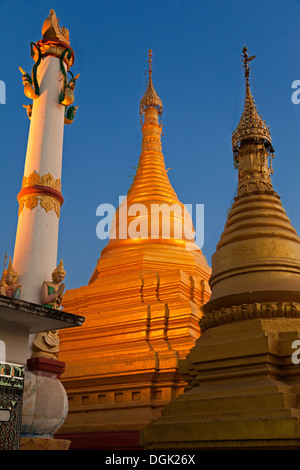 Pagoda illuminate al tramonto sulla cima della collina di Mandalay in Myanmar. Foto Stock