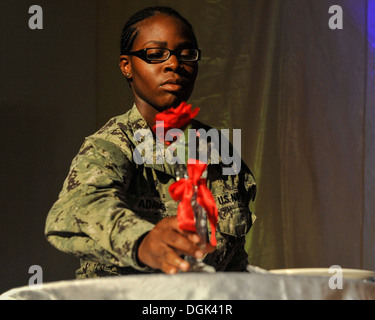 CAMP LEMONNIER, Gibuti (ott. 12, 2013) Attrezzatura operatore Constructionman Makayla Adams, assegnato alla Naval Mobile Battaglione di costruzione 11, pone una rosa sui prigionieri di guerra/mancante in azione tabella durante la Marina palla su Camp Lemonnier. La sfera wa Foto Stock