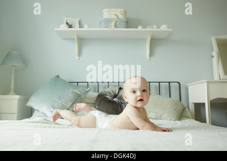 Bambino giacente sulla parte anteriore sul letto Foto Stock