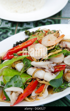 Vista superiore a base di erbe fritte di verdure con gamberi e calamari sul piatto Foto Stock