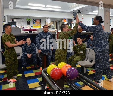 NAVAL AIR FACILITY Misawa combatté, Giappone (ott. 17, 2013) Ospedale Corpsman 1a classe Tracy-Ann West, originariamente da san Tommaso, Giamaica, alta cinque un soldato dal Giappone terra Forza di Autodifesa (JGSDF) durante un accordo bilaterale in materia di relazioni con la comunità caso tra il brevetto statunitense n. Foto Stock