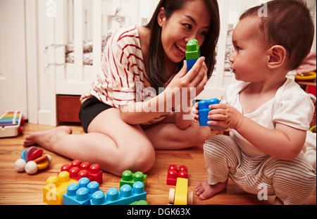 La madre e il bambino gioca con blocchi di costruzione Foto Stock