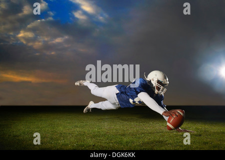 Giocatore di football americano raggiungendo per touch down Foto Stock