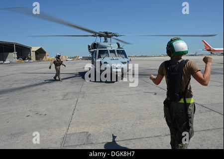 Sailor assegnato al mare in elicottero Combat Squadron (HSC) 26 guida un pilota verso un MH-60S Seahawk elicottero. HSC-26 Det. 1 è Foto Stock