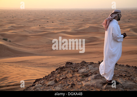 Un uomo si affaccia nel deserto di Dubai. Foto Stock