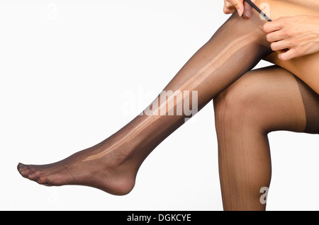 Gambe femmina con un collant strappati su Foto Stock