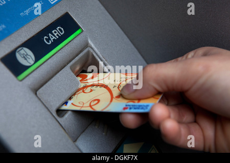 Inserire la carta di credito in una macchina ATM Foto Stock