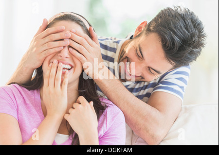 Uomo che copre occhi di donna con le mani Foto Stock