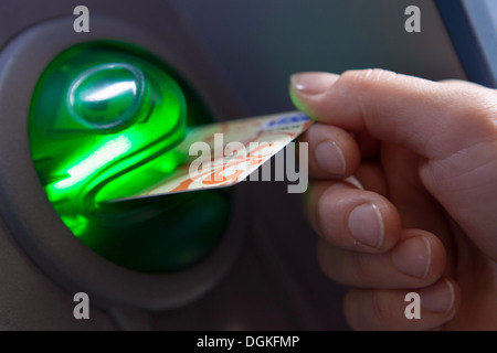 Mano inserire la carta di credito in un bancomat Foto Stock