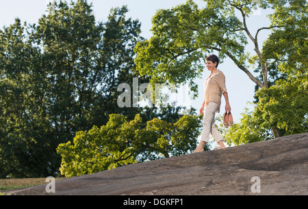 Donna matura camminando sul rock Foto Stock