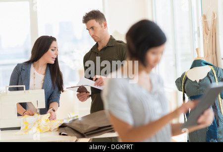 Tre fashion designer che lavorano in studio Foto Stock