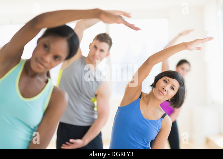 La gente lo stiramento in palestra Foto Stock