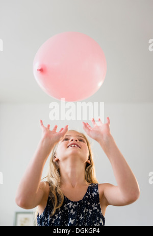 La ragazza (8-9) giocando con palloncino rosa Foto Stock