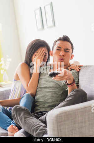 Giovane donna e giovane uomo seduto sul divano Foto Stock