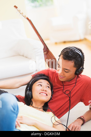 Giovane donna e uomo che ascolta musica con le cuffie sul Foto Stock