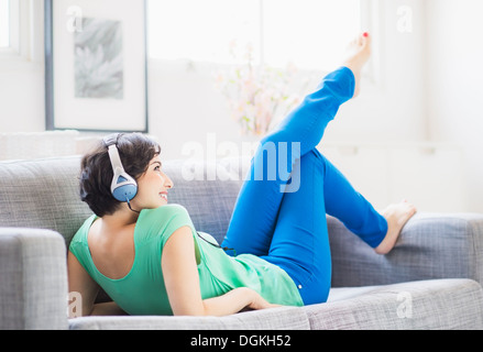 Giovane donna ascoltando la musica a casa Foto Stock