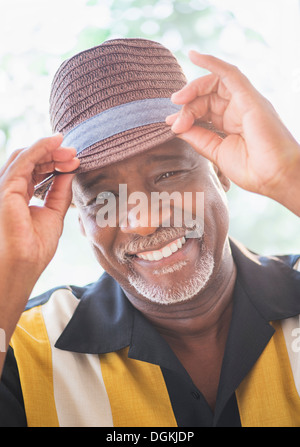Ritratto di felice senior uomo che indossa cappello di paglia Foto Stock