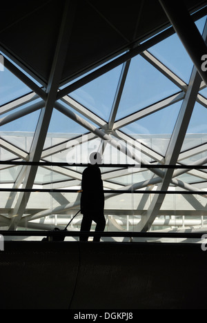 Un uomo cammina attraverso la stazione ferroviaria di King's Cross atrio occidentale. Foto Stock