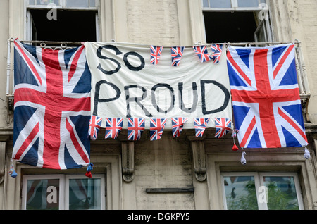 Banner e Union Jack Flag appeso al di fuori di un edificio di Londra durante il London 2012 sfilata di atleti. Foto Stock