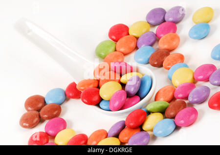 Smarties cioccolatini su un cucchiaio di porcellana Foto Stock