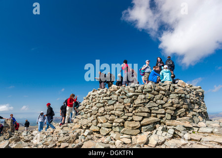 I turisti su cairn al vertice di Scafell Pike. Foto Stock