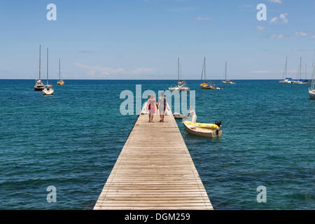 Due persone che camminano su un molo, Deshaies Guadalupa, Piccole Antille, dei Caraibi Foto Stock