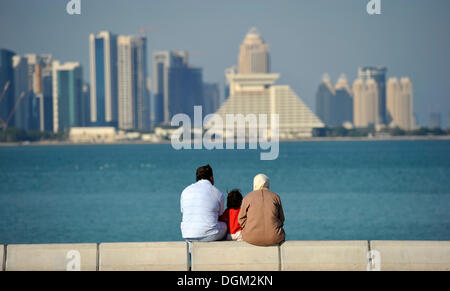 Famiglia sulla Corniche, promenade, albergo Sheraton skyline di Doha, Qatar, Golfo Persico, Medio Oriente e Asia Foto Stock