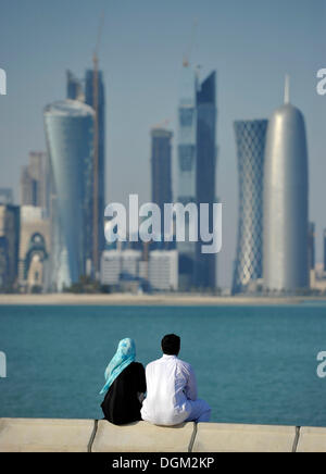 Giovane sulla Corniche, promenade, skyline di Doha, Qatar, Golfo Persico, Medio Oriente e Asia Foto Stock