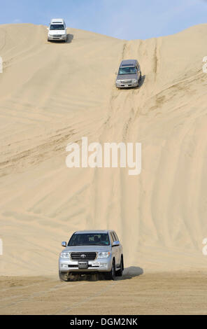 Tre off-roaders guida nelle dune di sabbia, emirato del Qatar, Golfo Persico, Medio Oriente e Asia Foto Stock
