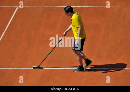 Campo da tennis manutenzione, pulizia groundskeeper linea bianca su clay court Foto Stock