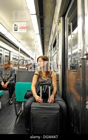 Giovane donna con una valigia nella metropolitana di Parigi, Francia, Europa Foto Stock