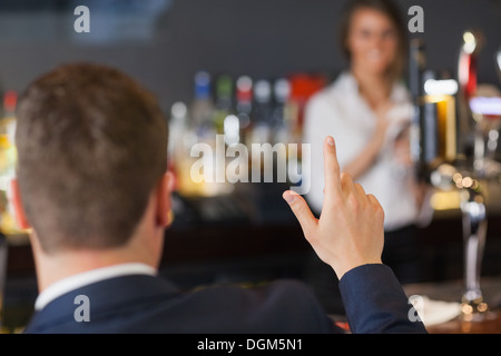 Uomo bello ordinare un drink dalla bella cameriera Foto Stock