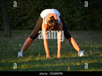Giovane donna in riscaldamento, esercizi di stretching, Stoccarda, Baden-Wuerttemberg, PublicGround Foto Stock