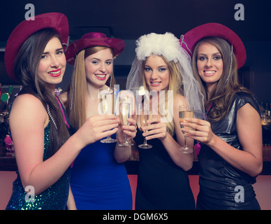 Attraente amici tintinnanti bicchieri di champagne a notte di gallina Foto Stock