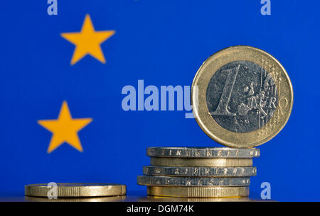 Monete metalliche in euro con una bandiera europea, immagine simbolica per la crisi dell'euro Foto Stock