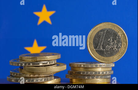 Monete metalliche in euro con una bandiera europea, immagine simbolica per la crisi dell'euro Foto Stock
