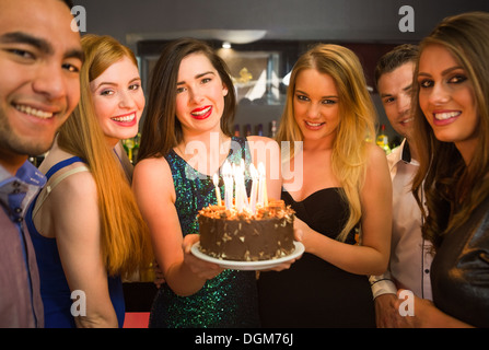 Happy amici celebra un compleanno holding torta di compleanno Foto Stock