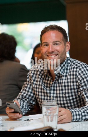 La gente di affari. Un uomo seduto a un tavolo in un bar o caffè. Foto Stock