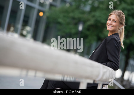 Una giovane donna bionda su una città di New York Street. Indossa una giacca nera. Foto Stock