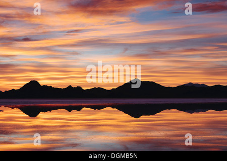 Il cielo al tramonto. Strati di cloud riflettendo in acque poco profonde allagando la Bonneville Saline Foto Stock