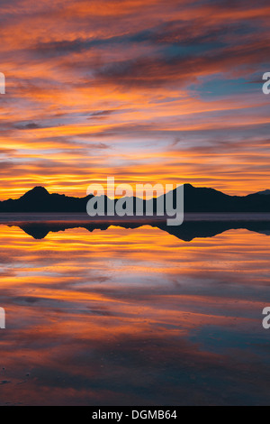 Il cielo al tramonto. Strati di cloud riflettendo in acque poco profonde allagando la Bonneville Saline Foto Stock