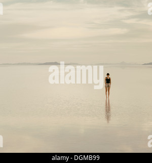 Donna in piedi sul allagato Bonneville Saline, al tramonto. Foto Stock
