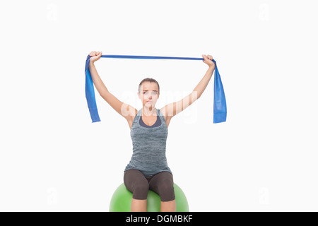 Giovane donna seduta di formazione su una sfera di fitness Foto Stock