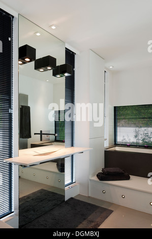 Bagno in bianco e nero con specchio spotlit Foto Stock