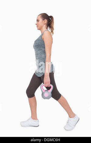 Donna sportivo della formazione il suo corpo a piedi con un bollitore bell Foto Stock