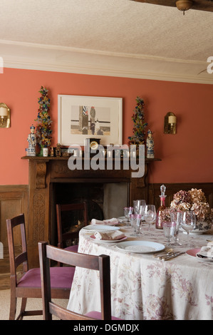 Tavolo da pranzo e caminetto a legno in casa di tessuto designer Richard Smith in East Sussex Foto Stock