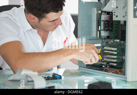 Bello ingegnere di computer riparazione di computer con una pinza Foto Stock