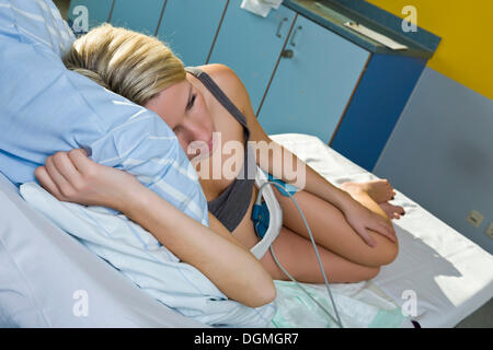 Donna incinta in appoggio su un letto di consegna durante il parto collegato ad un la cardiotocografia o CTG, Germania Foto Stock