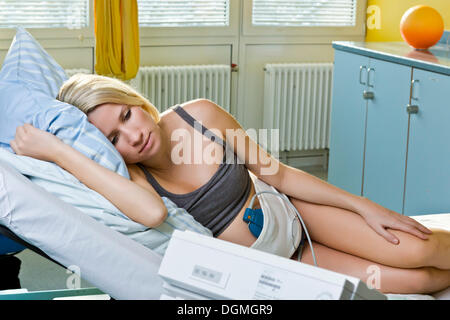 Donna incinta in appoggio su un letto di consegna durante il parto collegato ad un la cardiotocografia o CTG, Germania Foto Stock