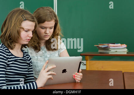 Due studentesse in aula utilizzando un tablet PC, Germania Foto Stock